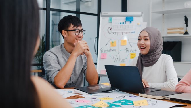 
Multiracial group of young creative people in smart casual wear discussing business brainstorming meeting ideas mobile application software design project in modern office. Coworker teamwork concept.
